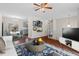 Inviting living room with hardwood floors, a stylish rug, and views into the kitchen and dining area at 7 Harrigan Ct, Durham, NC 27705