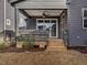 A covered back porch with steps leading down to the backyard at 705 Vine Pkwy, Pittsboro, NC 27312