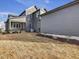 View of gray home's backyard featuring a covered patio and manicured flowerbeds at 705 Vine Pkwy, Pittsboro, NC 27312