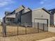 View of gray home's backyard featuring a fenced yard and small covered patio at 705 Vine Pkwy, Pittsboro, NC 27312