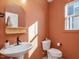 Charming powder room with a floating sink, neutral decor, and window at 705 Vine Pkwy, Pittsboro, NC 27312
