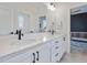 Bright bathroom featuring double vanity, white countertops and cabinetry, with black hardware accents at 705 Vine Pkwy, Pittsboro, NC 27312