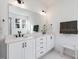 Bright bathroom with double sinks, white cabinets, sleek black hardware, and a large mirror at 705 Vine Pkwy, Pittsboro, NC 27312
