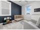 Modern Bedroom with blue accent wall, carpet flooring, a crib, and natural light from large windows at 705 Vine Pkwy, Pittsboro, NC 27312