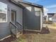 Home exterior with dark siding, backyard access, and wooden steps shows backyard and side door at 705 Vine Pkwy, Pittsboro, NC 27312