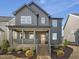 Charming two-story home with a welcoming front porch, landscaped yard, and stylish dark gray siding at 705 Vine Pkwy, Pittsboro, NC 27312