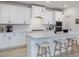 Bright kitchen with white cabinets, an island with bar seating, and stainless steel appliances at 705 Vine Pkwy, Pittsboro, NC 27312