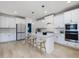 Bright kitchen features white cabinets, stainless appliances, and a center island with seating at 705 Vine Pkwy, Pittsboro, NC 27312