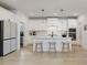 Bright kitchen boasts white cabinetry, center island with seating and pendant lighting at 705 Vine Pkwy, Pittsboro, NC 27312
