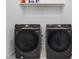 Laundry area with front-loading Samsung washer and dryer, shelving above, and tile flooring at 705 Vine Pkwy, Pittsboro, NC 27312