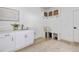 Bright mudroom features white cabinetry, built-in bench with storage, and a convenient sink area with modern fixtures at 705 Vine Pkwy, Pittsboro, NC 27312