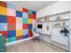 Office with colorful accent wall, wall mounted shelving unit, desk, and comfortable chair at 705 Vine Pkwy, Pittsboro, NC 27312
