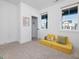 Sunlit room featuring large windows, neutral carpet, and cozy yellow sofa, creates a bright and inviting atmosphere at 705 Vine Pkwy, Pittsboro, NC 27312