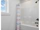 Clean white shower with a colorful curtain, black fixtures, and a window for natural light at 705 Vine Pkwy, Pittsboro, NC 27312