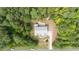 Aerial perspective of the property, displaying the house, driveway, and surrounding wooded area at 766 Horizon Dr, Pittsboro, NC 27312