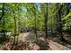 Backyard showcasing a swing set, hammock, wooden deck, stone patio and mature trees at 766 Horizon Dr, Pittsboro, NC 27312