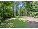 Large, level backyard with a mix of grass and wooded areas, ideal for outdoor activities at 766 Horizon Dr, Pittsboro, NC 27312