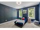 Cozy bedroom with a starry night accent wall, carpet and light filled windows at 766 Horizon Dr, Pittsboro, NC 27312