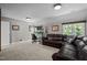 Comfortable living room with leather sofa, desk and chair and window views at 766 Horizon Dr, Pittsboro, NC 27312