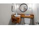 Close up on modern bathroom features a custom wooden sink, unique lighting and rounded mirror at 766 Horizon Dr, Pittsboro, NC 27312