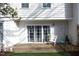 Cozy patio featuring sliding glass doors, a white chair, and a well-maintained, landscaped yard at 7736 Falcon Rest Cir, Raleigh, NC 27615