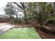 Backyard with a small area of green grass and surrounding mulch and trees at 7736 Falcon Rest Cir, Raleigh, NC 27615