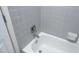 A clean and bright bathtub with tiled surround, faucet, and a shower head for relaxation and rejuvenation at 7736 Falcon Rest Cir, Raleigh, NC 27615