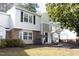 Charming townhome featuring a brick facade, large windows, and manicured landscaping at 7736 Falcon Rest Cir, Raleigh, NC 27615