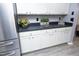 Bright kitchen features white cabinets, stainless refrigerator, and dark countertops at 7736 Falcon Rest Cir, Raleigh, NC 27615