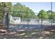 Community tennis court surrounded by a chain link fence and lush green trees at 7736 Falcon Rest Cir, Raleigh, NC 27615