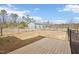 Backyard with a wooden deck, metal building, and a black chain link fence at 7880 Flower Hill Rd, Middlesex, NC 27557