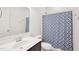 Bathroom featuring vanity, toilet, shower with blue patterned curtain, and neutral wall color at 7880 Flower Hill Rd, Middlesex, NC 27557