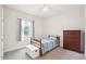 Cozy bedroom featuring single bed, dresser, neutral carpet, and natural light at 7880 Flower Hill Rd, Middlesex, NC 27557