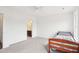 Neutral carpeted bedroom with open doorway to a bathroom and a bed at 7880 Flower Hill Rd, Middlesex, NC 27557