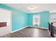 Upstairs bonus room with wood flooring, light blue walls, and natural light at 7880 Flower Hill Rd, Middlesex, NC 27557