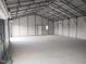 Spacious garage interior featuring a metal frame, concrete floor, and ample storage space at 7880 Flower Hill Rd, Middlesex, NC 27557