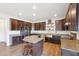 A large kitchen with wood floors, a center island, stainless steel appliances, and dark wood cabinets at 7880 Flower Hill Rd, Middlesex, NC 27557