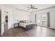 A spacious main bedroom suite with wood floors, tray ceiling, fan, and a door to the outside deck at 7880 Flower Hill Rd, Middlesex, NC 27557