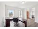 A spacious home office with ample natural light from two windows and dark wood accents at 7880 Flower Hill Rd, Middlesex, NC 27557