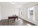 A home office space with a dark desk, chair, and natural light from large windows, and wood floors at 7880 Flower Hill Rd, Middlesex, NC 27557