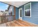 Covered back porch with wood flooring and blue siding at 8008 Hergety Dr, Raleigh, NC 27603
