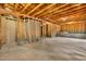 Unfinished basement with concrete walls, exposed ceiling beams, wood framing, and a concrete floor at 8008 Hergety Dr, Raleigh, NC 27603