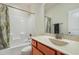 Cozy bathroom with tub, shower and sink with wood cabinets and patterned shower curtain at 8008 Hergety Dr, Raleigh, NC 27603