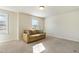 Bonus room with tan couch and bright windows at 8008 Hergety Dr, Raleigh, NC 27603