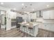 A bright kitchen features a large center island, stainless steel appliances, and modern pendant lighting at 824 Wrights Creek Way, Wake Forest, NC 27587