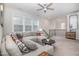 Cozy living room features a large sectional sofa, ceiling fan, and abundant natural light at 824 Wrights Creek Way, Wake Forest, NC 27587