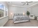 Main bedroom with plush bed, ceiling fan, sitting area, and lots of natural light at 824 Wrights Creek Way, Wake Forest, NC 27587