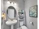 Stylish half-bathroom with pedestal sink, decorative mirror, ladder shelf, and modern fixtures at 90 Rigsby Ave, Four Oaks, NC 27524