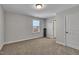 Spacious, empty bedroom with plush carpeting, natural light, and ample potential for customization at 90 Rigsby Ave, Four Oaks, NC 27524