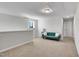 Spacious bonus room with plush carpet, natural light, and comfortable green couch at 90 Rigsby Ave, Four Oaks, NC 27524